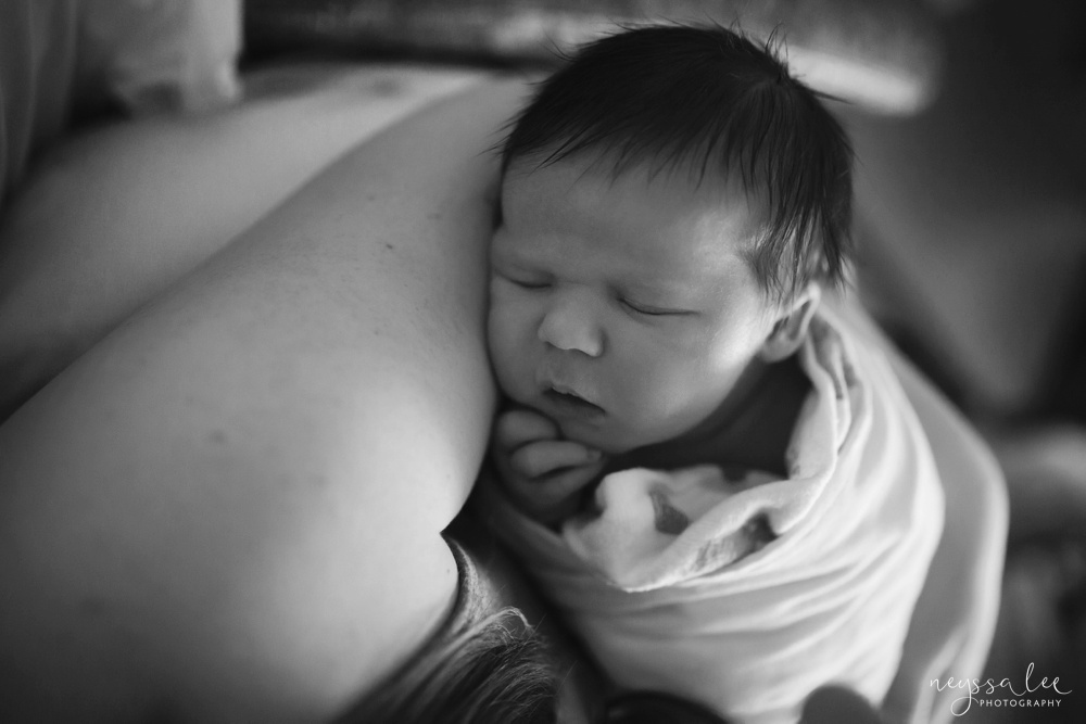 Sleeping newborn wrapped in swaddle, black and white photo