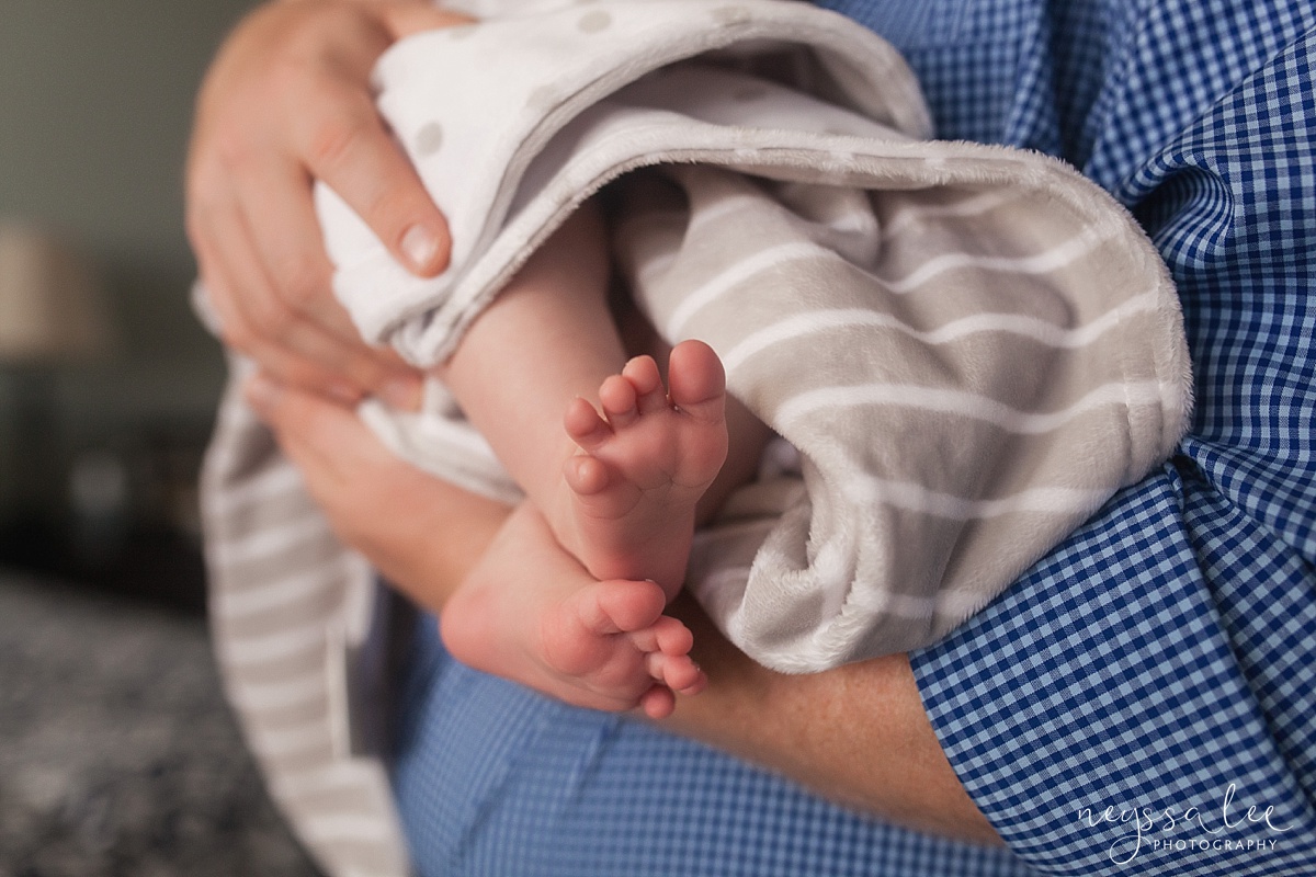 Newborn baby toes in dad's arms