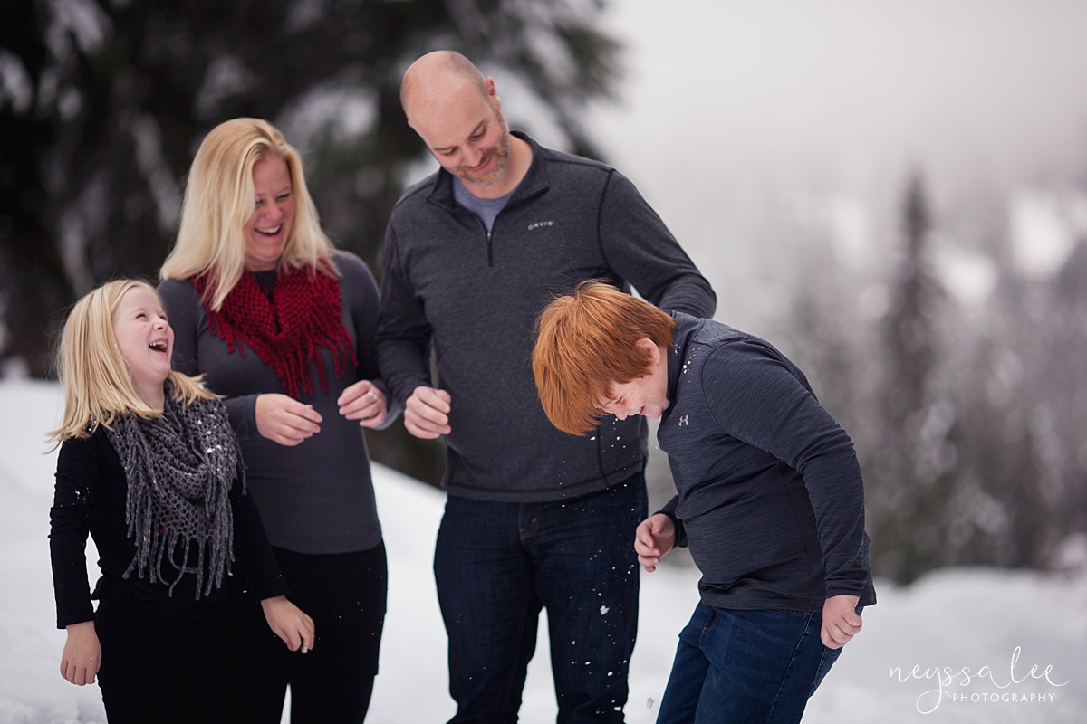 Family laughing during snowball fight 