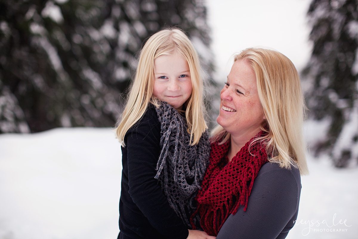 mother admires daughter in snow