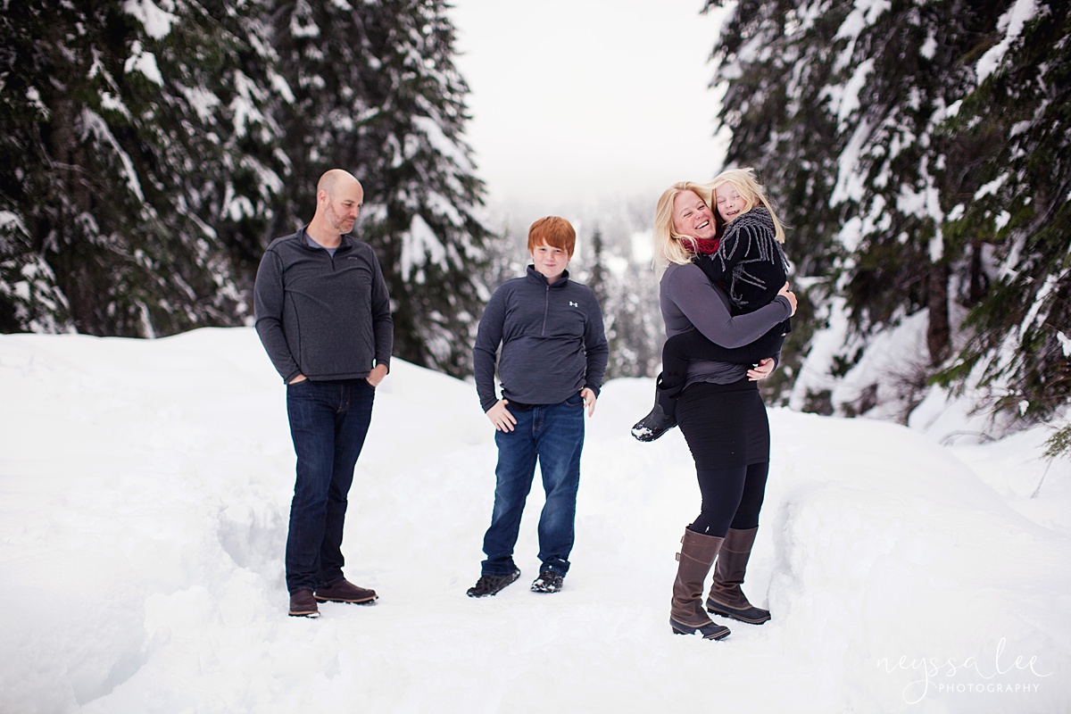 Family plays in snow, girl in mothers arms