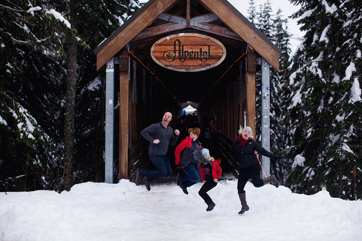 Family jumping in the snow in front of entry of Alpental bridge