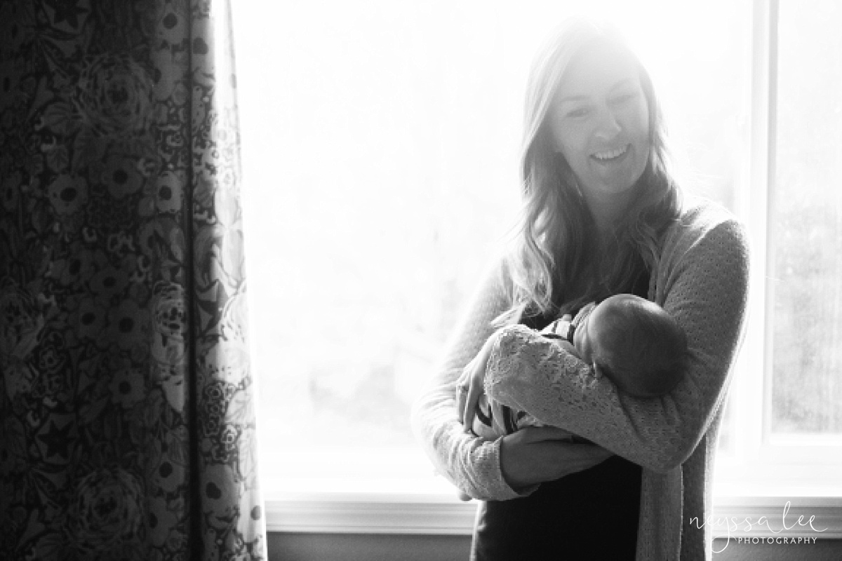 Newborn boy in mom's arms, black and white lifestyle newborn photo