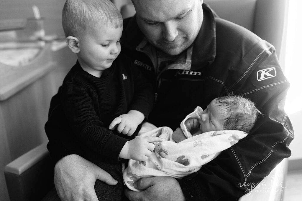 black and white photo of father with two sons in hospital for Fresh 48 portraits