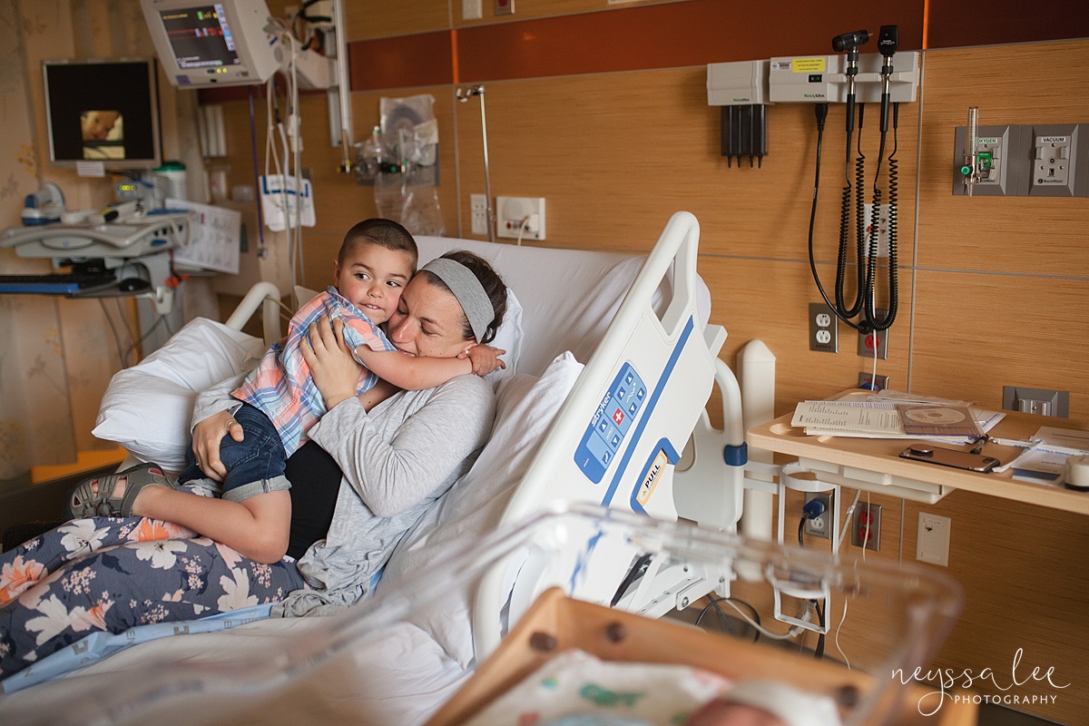 Son hugging mother in hospital bed at Swedish Issaquah hospital during Fresh 48 photos