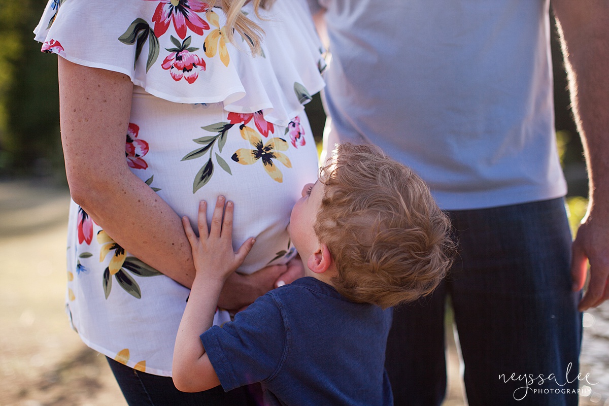 Boy kisses baby bump during snoqualmie pass maternity photos at Gold Creek Pond