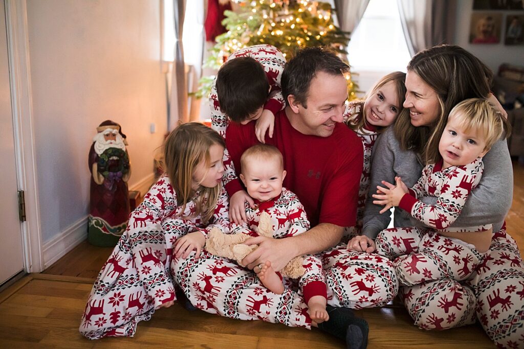 Family in matching pjs by the Christmas Tree