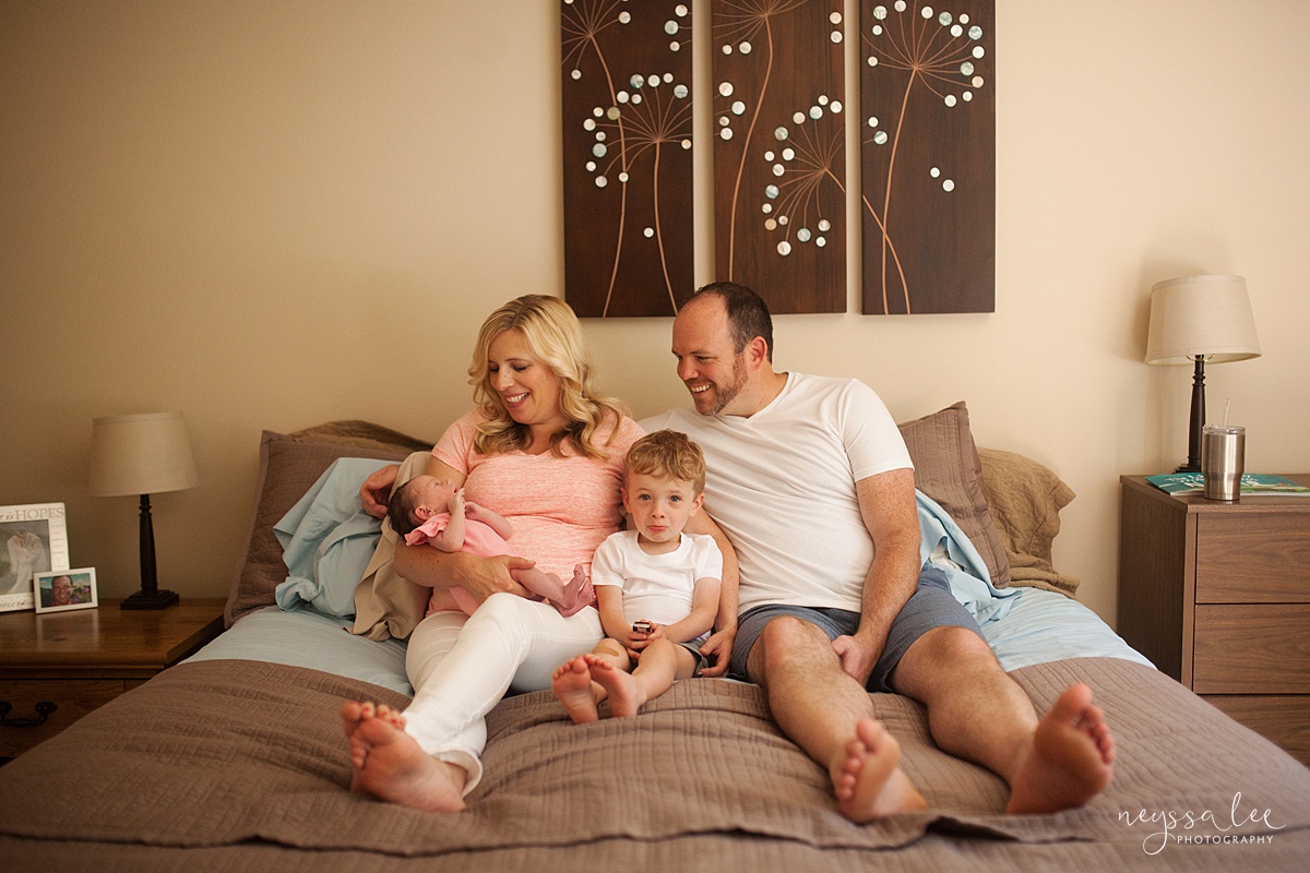 Lifestyle newborn photography, Family with newborn baby snuggled on parents bed during Snoqualmie newborn photo session