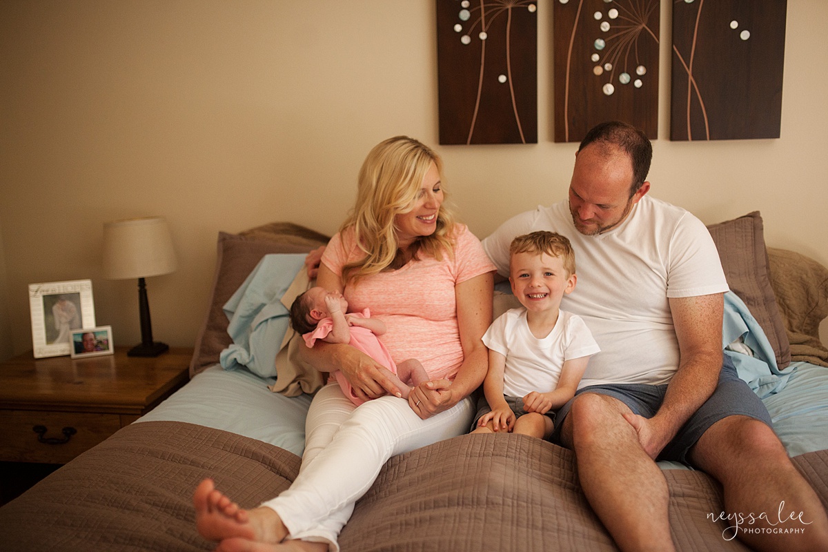 Family on the big bed for family photos with baby