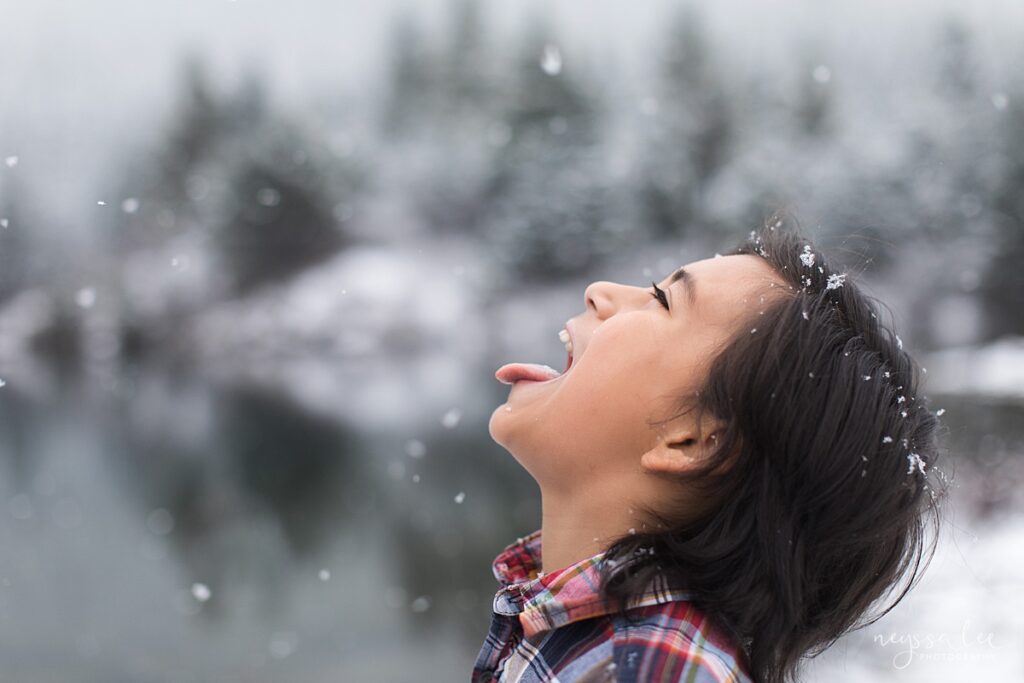 boy catching snowflakes during Seattle winter family portrait session
