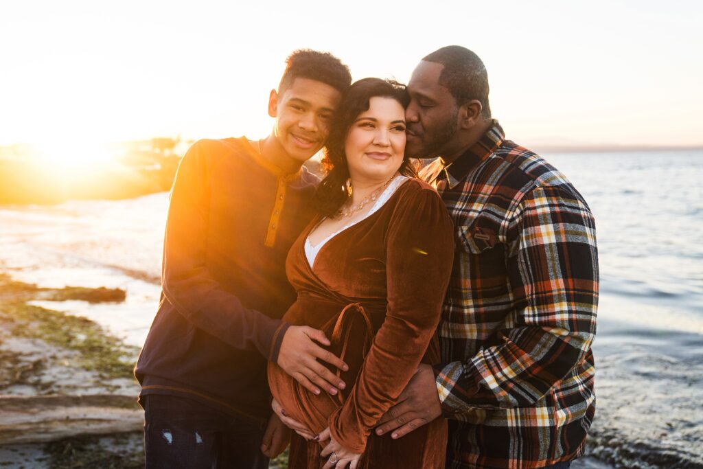 Maternity session with older son and husband on Seattle beach at sunset