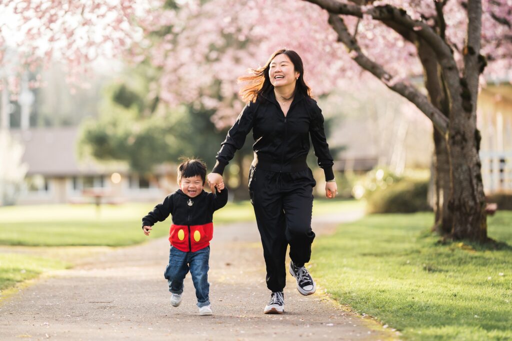 Mother and toddler boy running together during spring family photos in North Bend, Wa