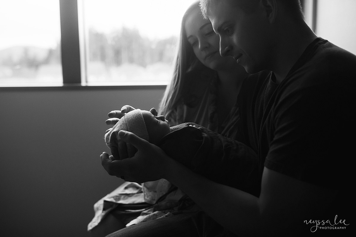Black and white photo of mom and dad admiring newborn baby for Issaquah fresh 48 photo session