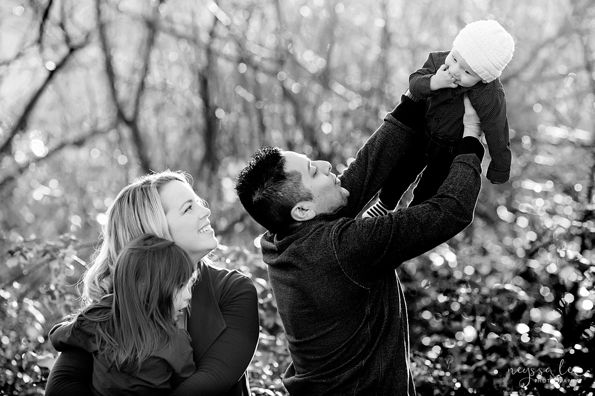 Uncooperative Kids During Family Photos, Neyssa Lee Photography, Seattle Family Photographer, Issaquah Photography, Black and white photo of family of four with dad lifting baby into the air