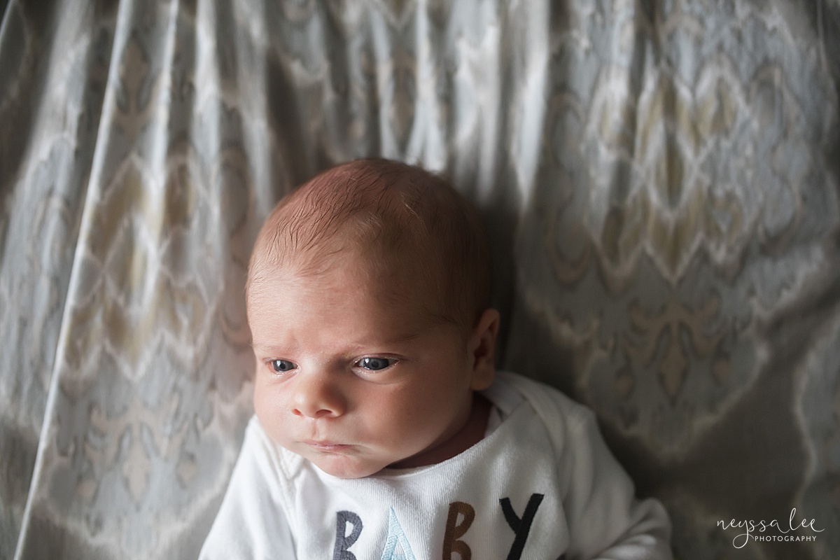 Lifestyle newborn portrait of baby boy on bed