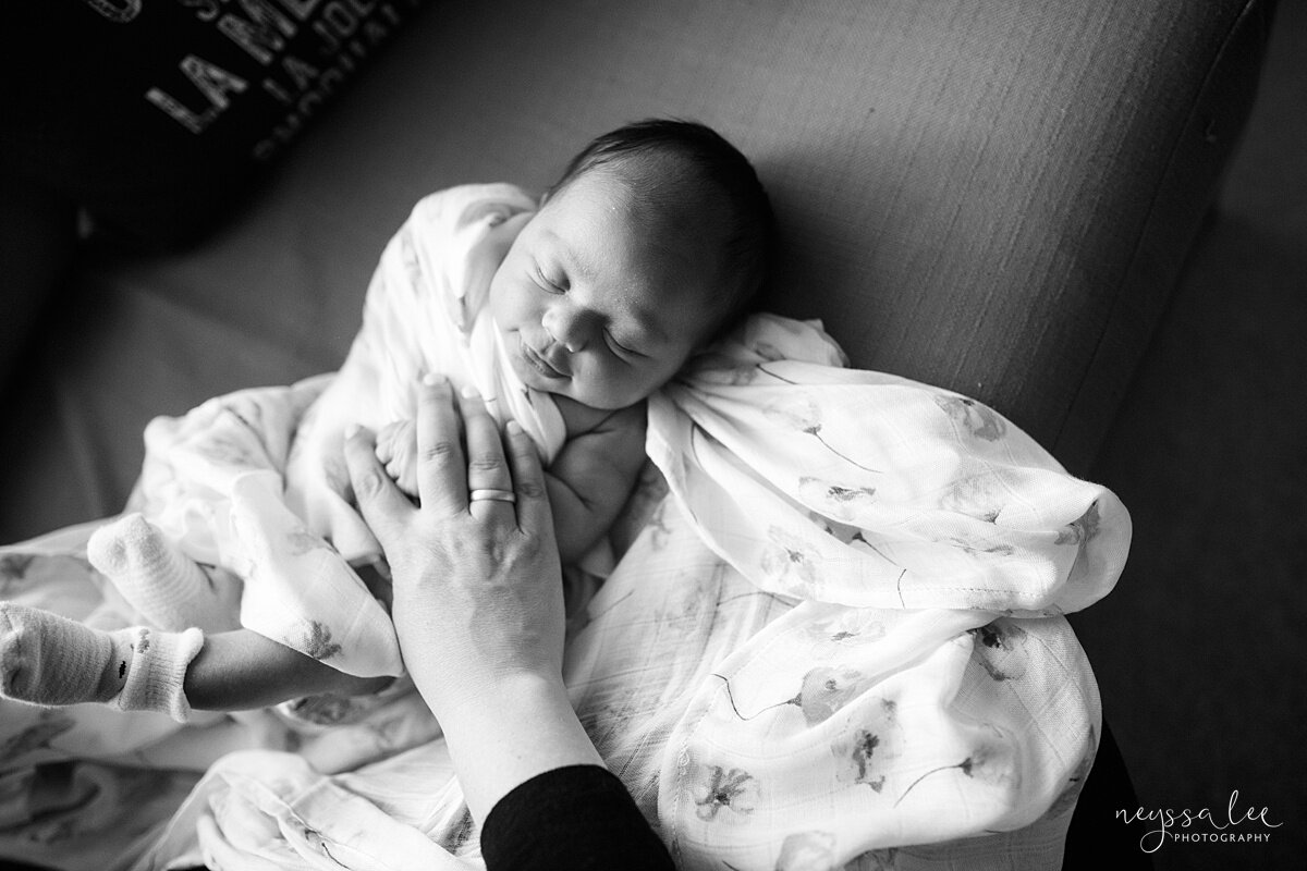 Black and white photo of mom swaddling newborn baby by Snoqualmie photographer