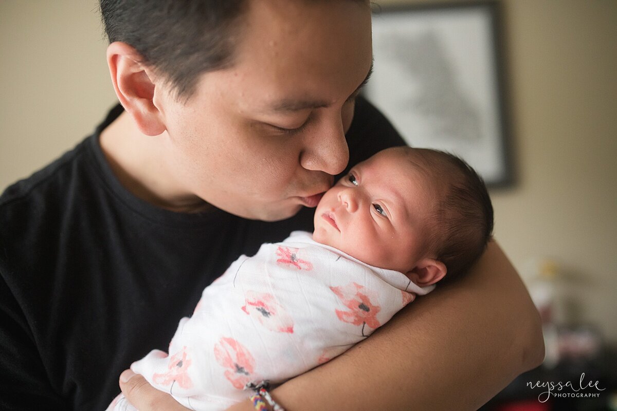 Photo of dad kissing newborn baby girl during Seattle newborn photo session