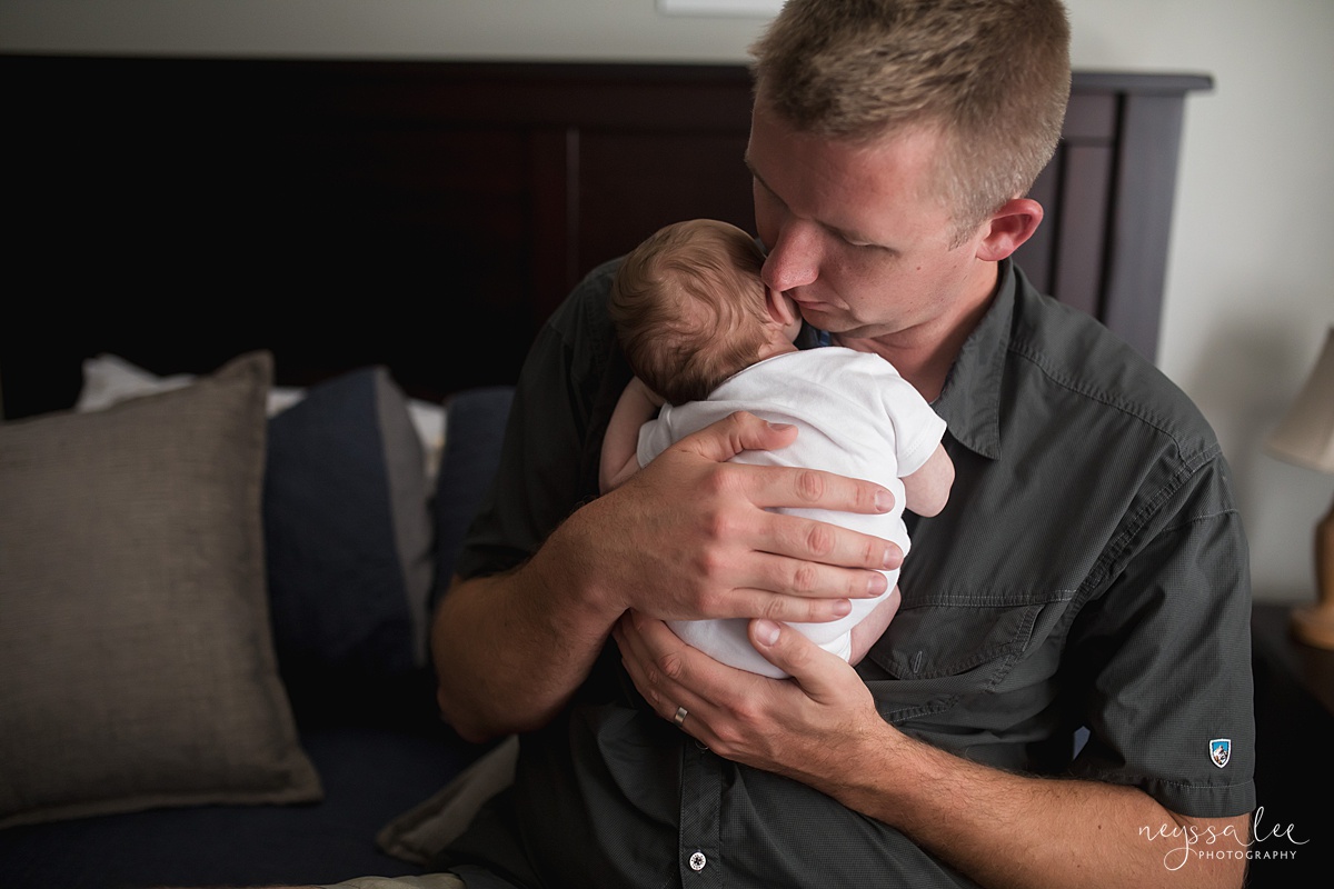 Your Newborn Photo Session Questions Answered, Issaquah Newborn Photographer, Neyssa Lee Photography, Photo of dad holding newborn baby boy against his chest, Seattle newborn photography