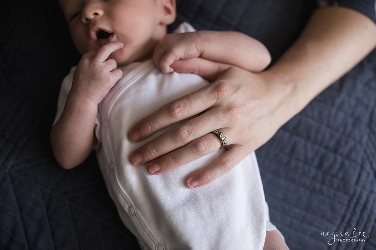 Photo of newborn baby boy with mom's hand on his chest