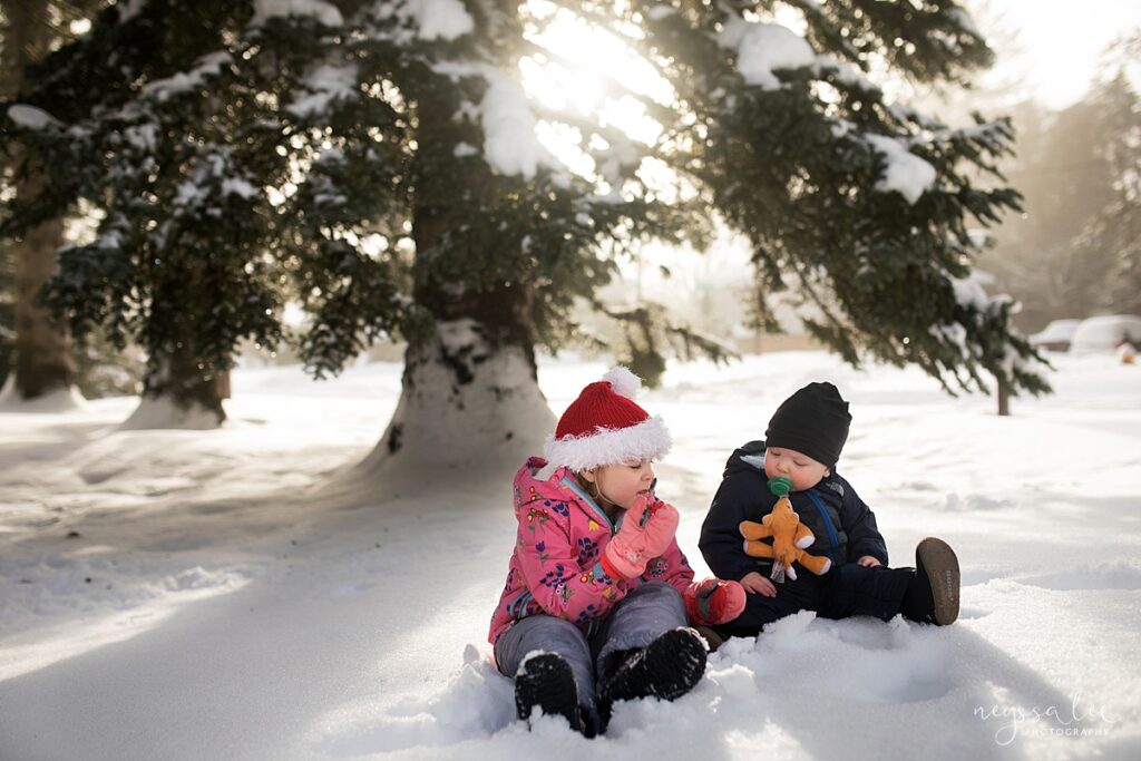 Photo of children eating snow together in beautiful backlight sun