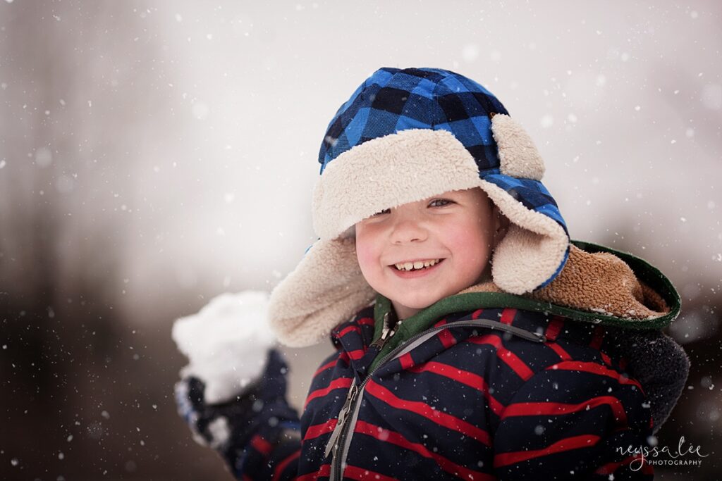 Boy about to throw a snowball and smiling