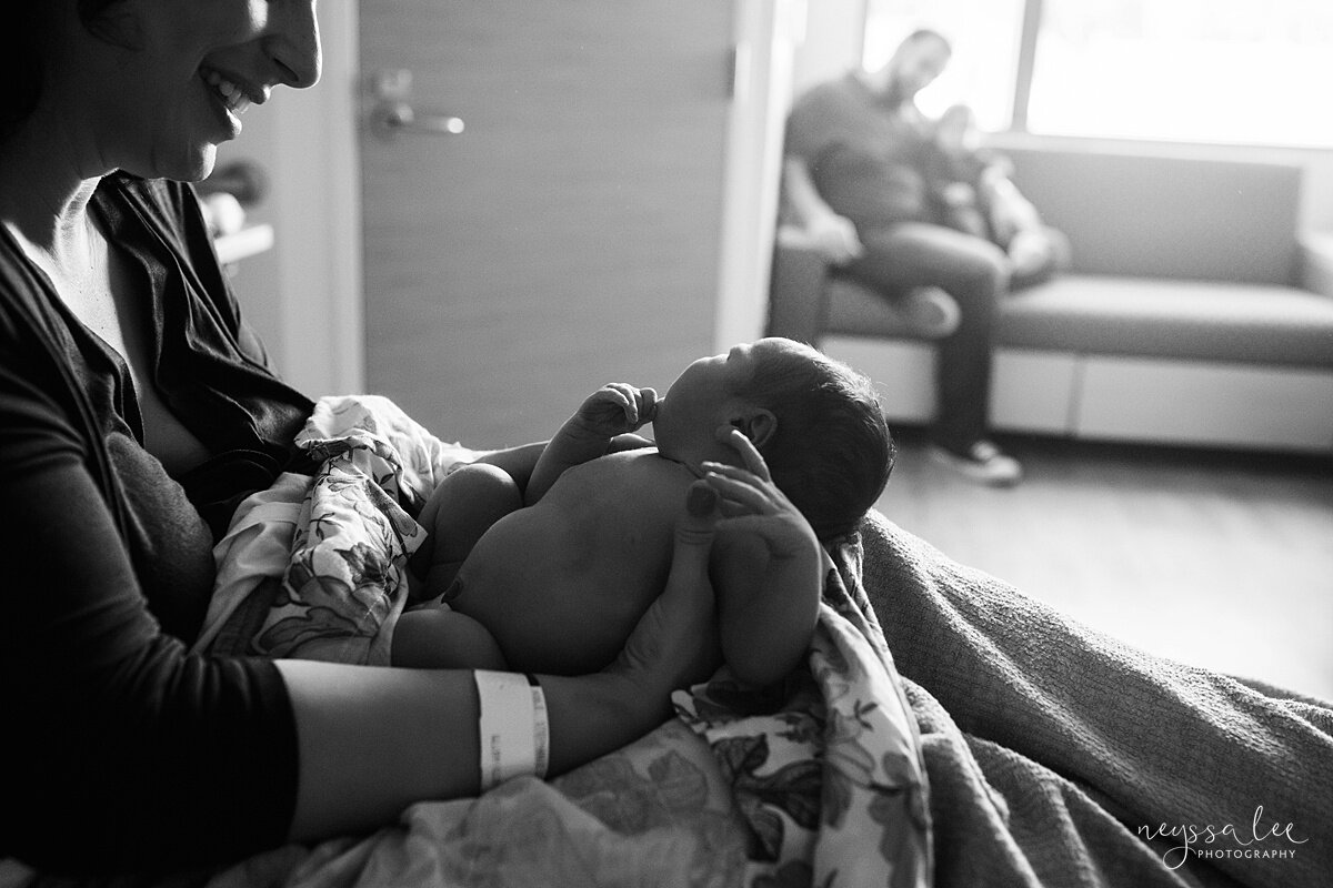 Black and white photo of mom admiring newborn baby girl in hospital photos
