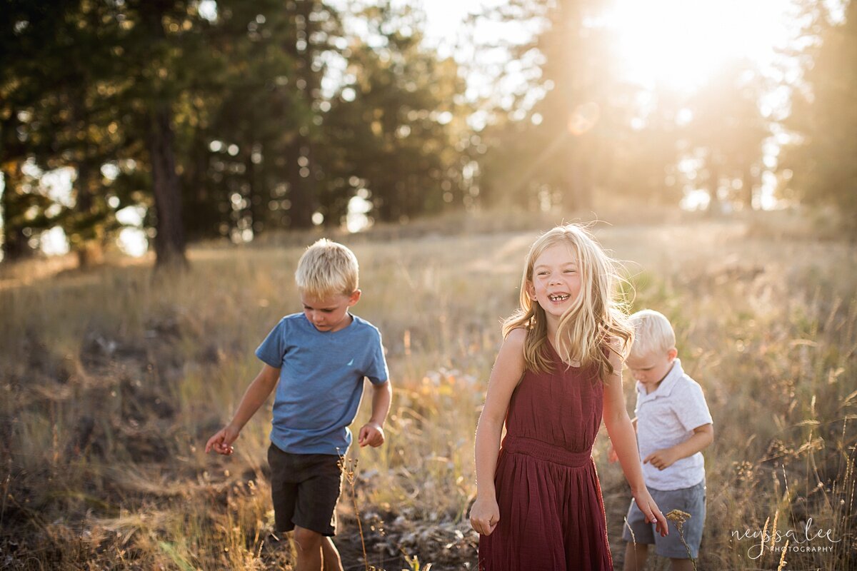 Benefits of family photos on vacation, Neyssa Lee Photography, Chelan Family Photographer, Photo of three kids laughing in a field