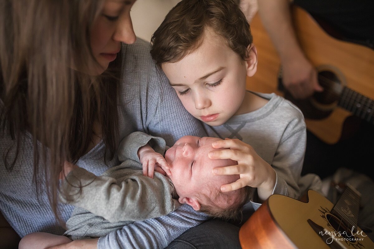 Lifestyle newborn photo of boy loving on baby by Snoqualmie newborn photographer Neyssa Lee