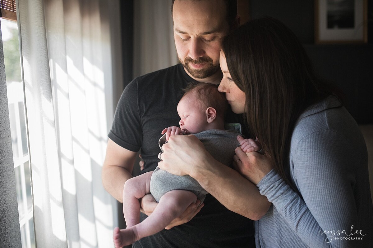 Number One thing you can do for beautiful newborn photos, Issaquah newborn photographer, Neyssa Lee Photography, Lifestyle newborn photo of parents adoring baby in natural window light