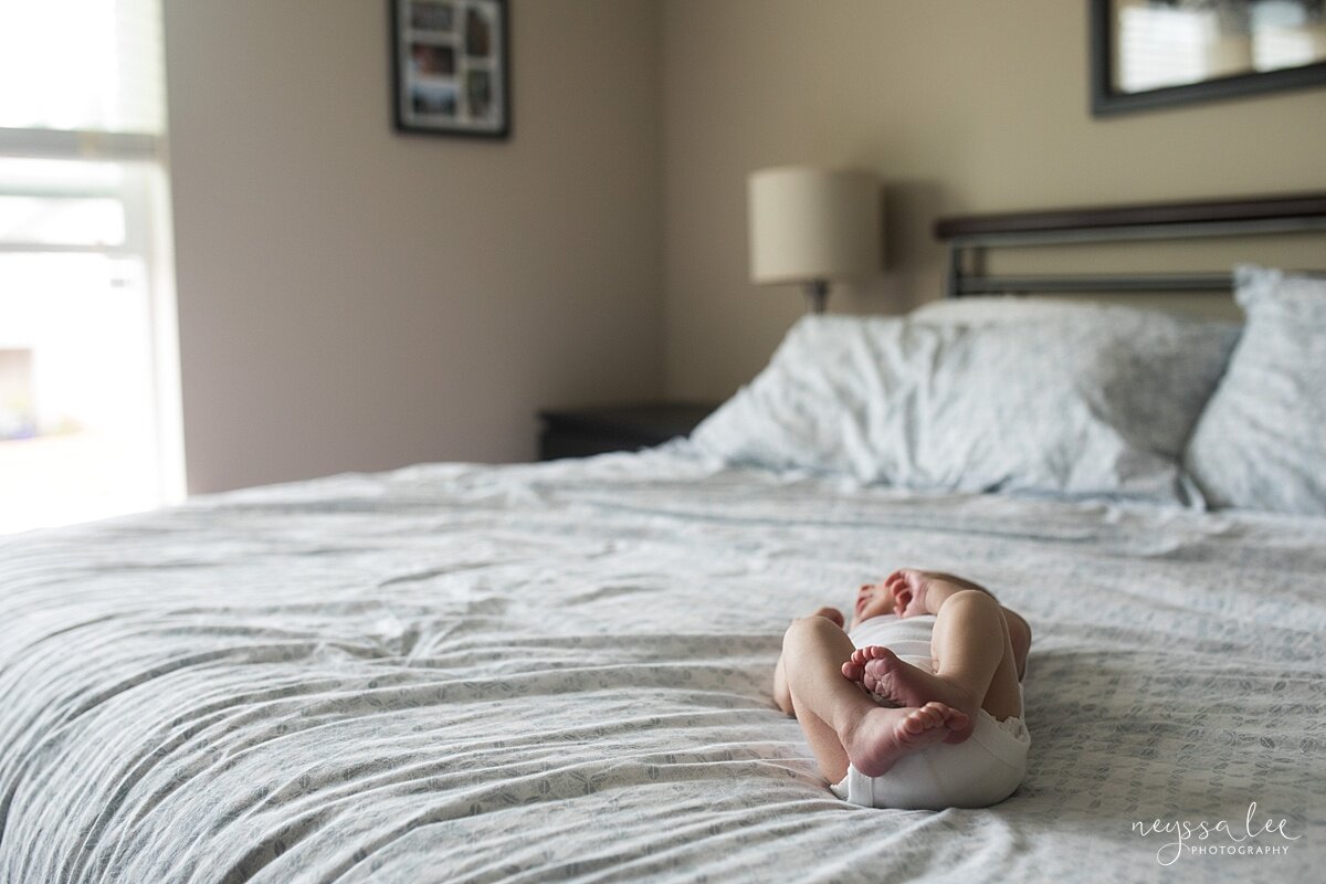  Lifestyle newborn photo of baby on master bed