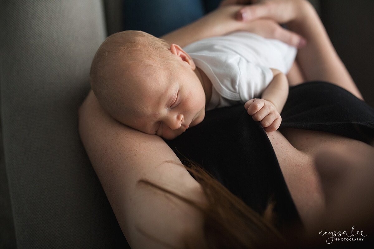 Lifestyle newborn photography session photo of baby in mom's arms