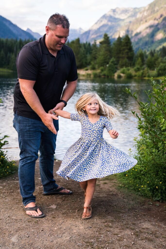 Father twirling daugther in Alice and Ames floral dress during Snoqualmie Pass Mountain Photoshoot