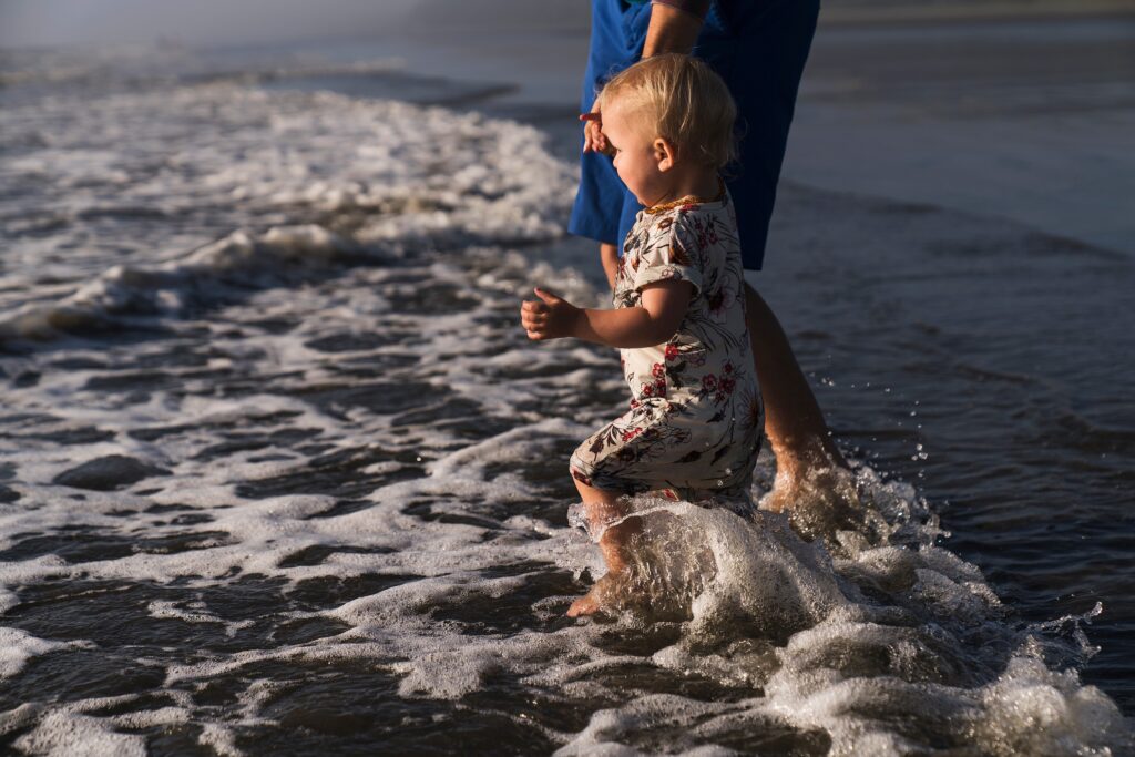 Toddler jumping waves at Seabrook beach on Wa coast for photography tip
