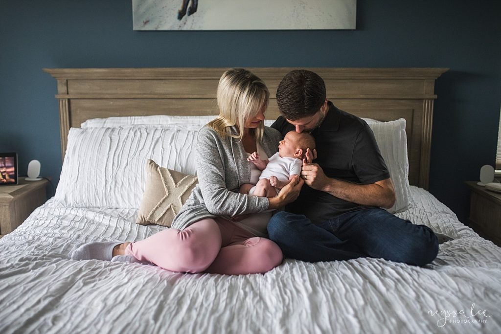 what to wear for newborn photography session, mother and father with newborn baby on master bed