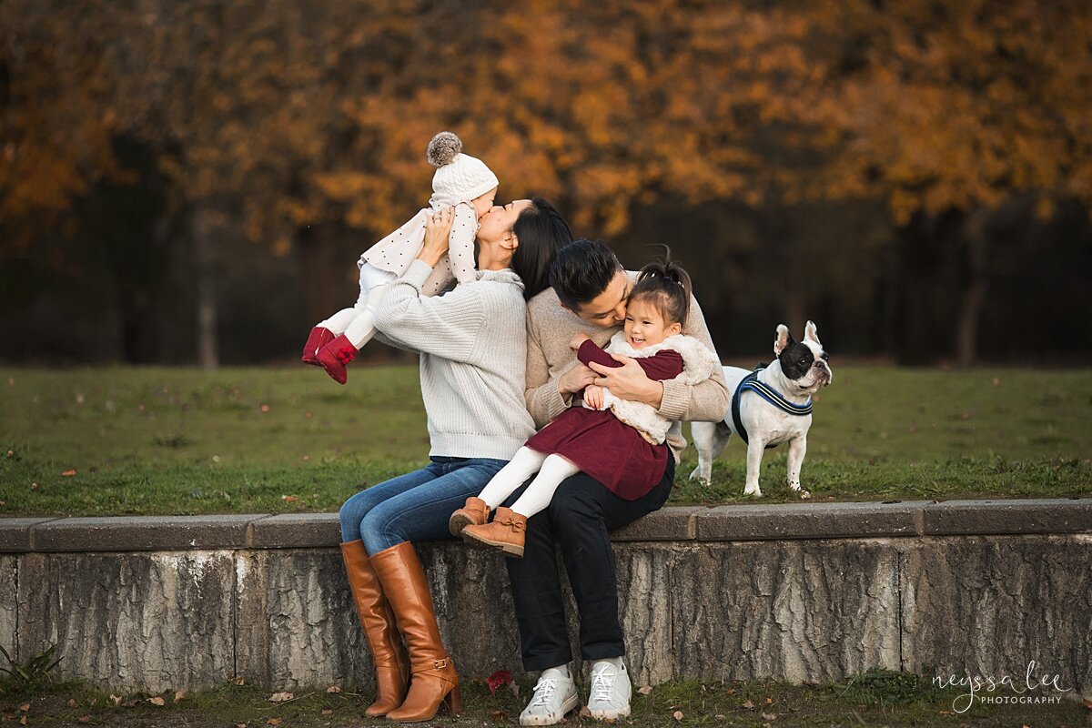 3 Tips for Keeping Baby Warm for Family Photos, Neyssa Lee Photography, Seattle Fall Family Photos, Photo of family snuggled together on park wall