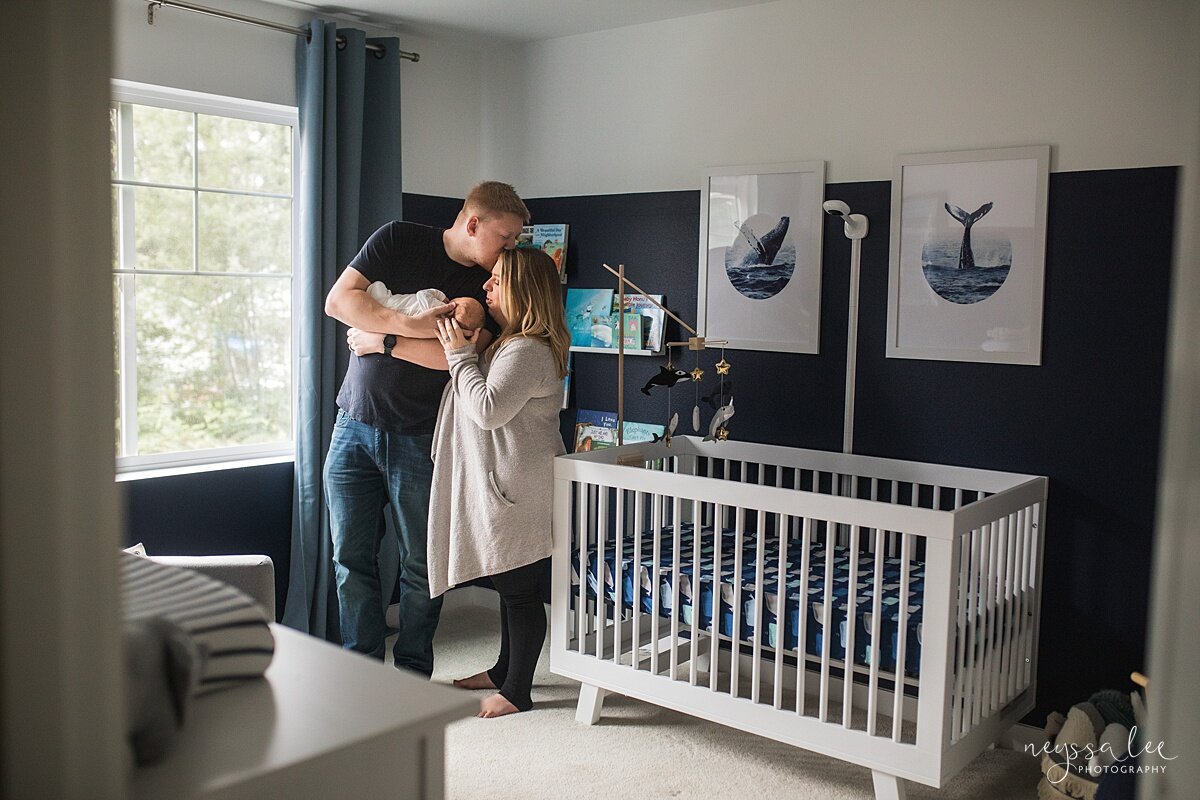 Family holding baby in whale themed nursery