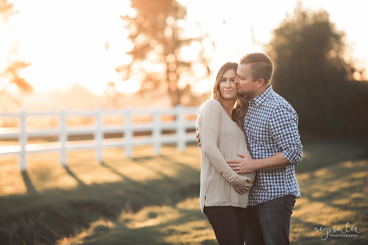 Photo of husband and pregnant wife with golden sunlight behind them