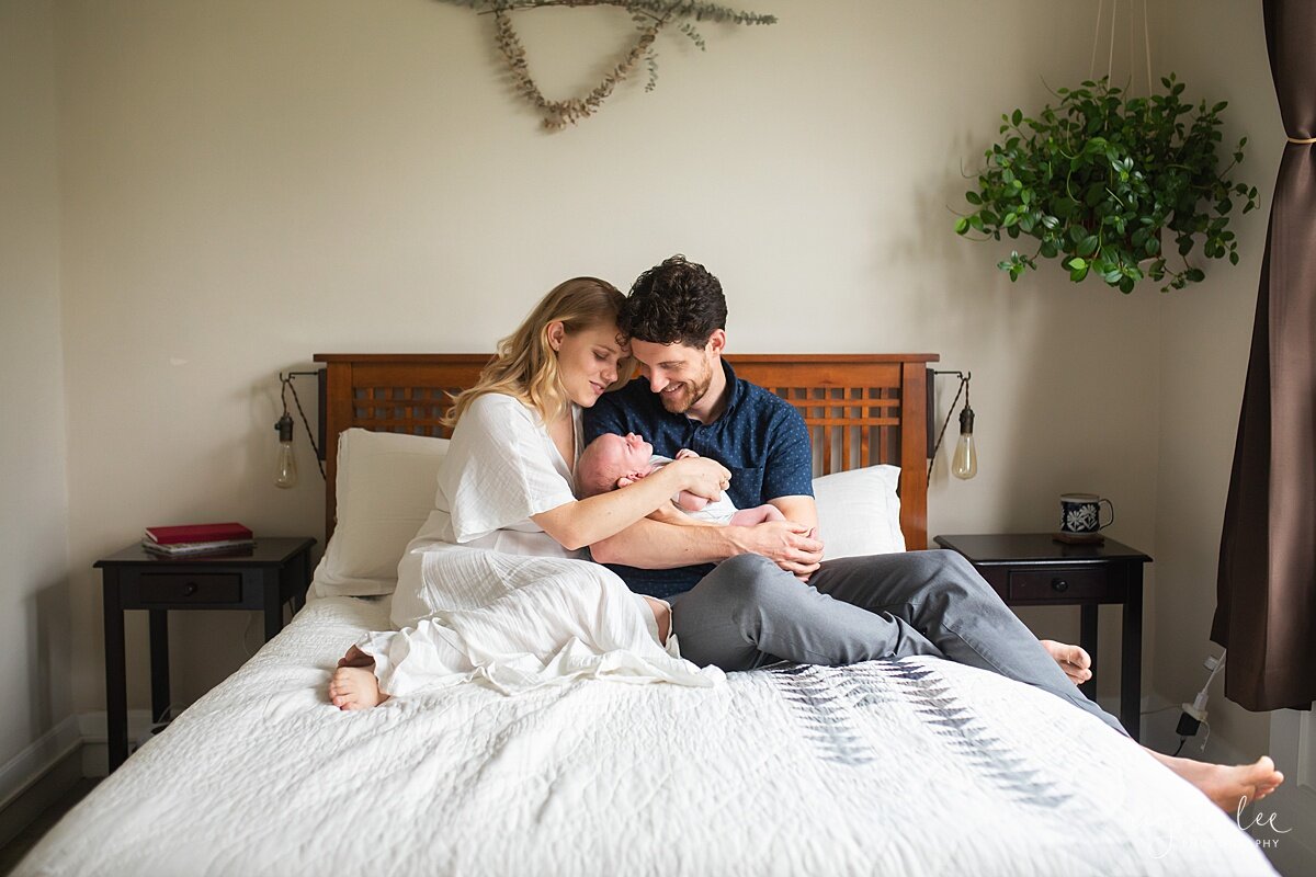Why I Do Not Use Props for Newborn Photos, Seattle Newborn Photographer, Neyssa Lee Photography, Photo of parents cuddled on master bed with newborn baby