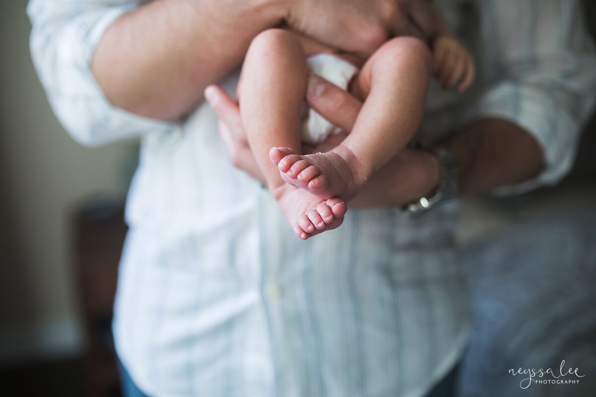 Newborn Toes as baby is held against dad's chest