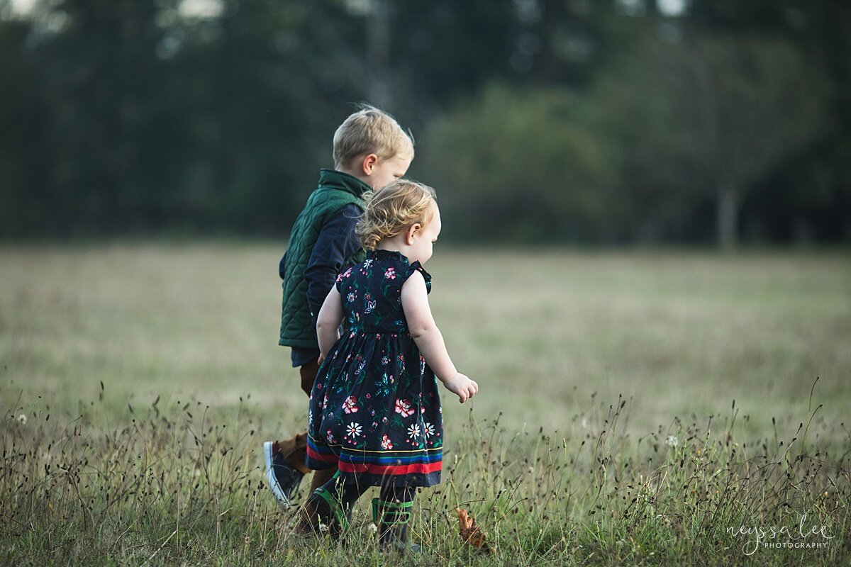 Siblings walking through field at Tanner Landing Park