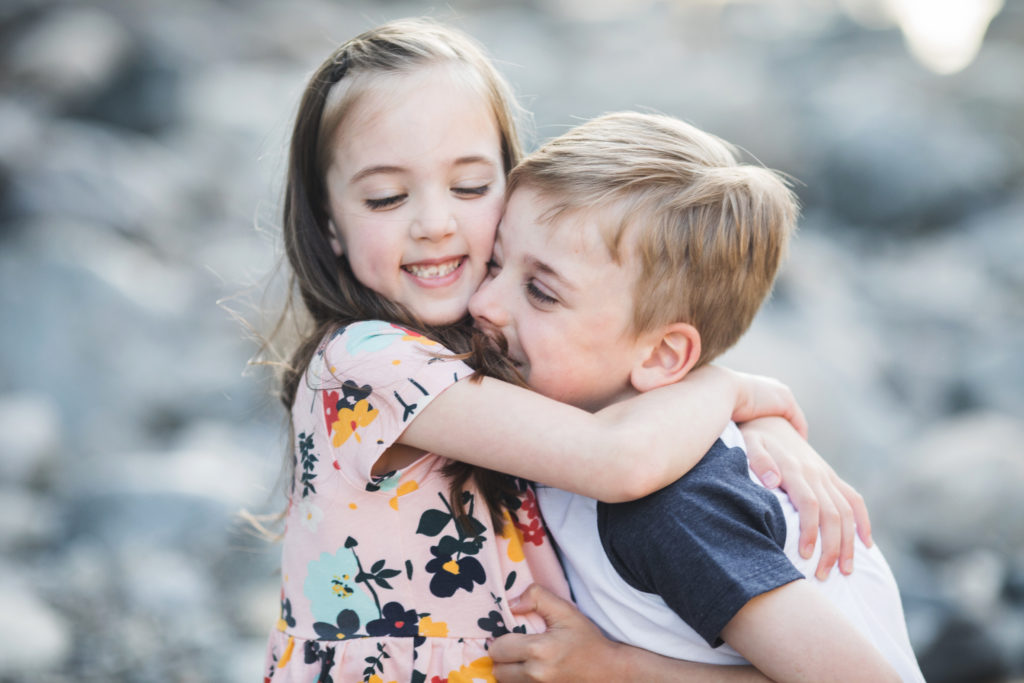 Photo of siblings hugging during outdoor family photo session