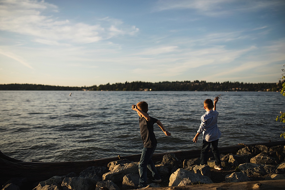Photo of boys throwing rocks into water during Seattle area family photo ssession