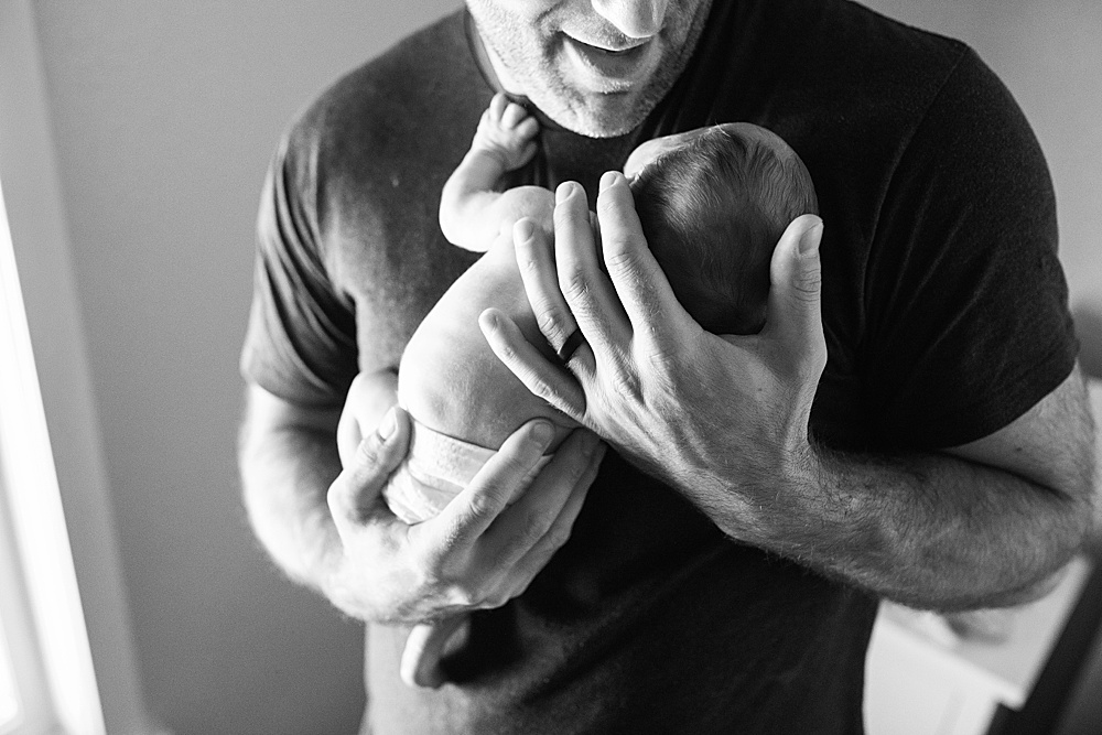 black and white photo of dad with newborn baby