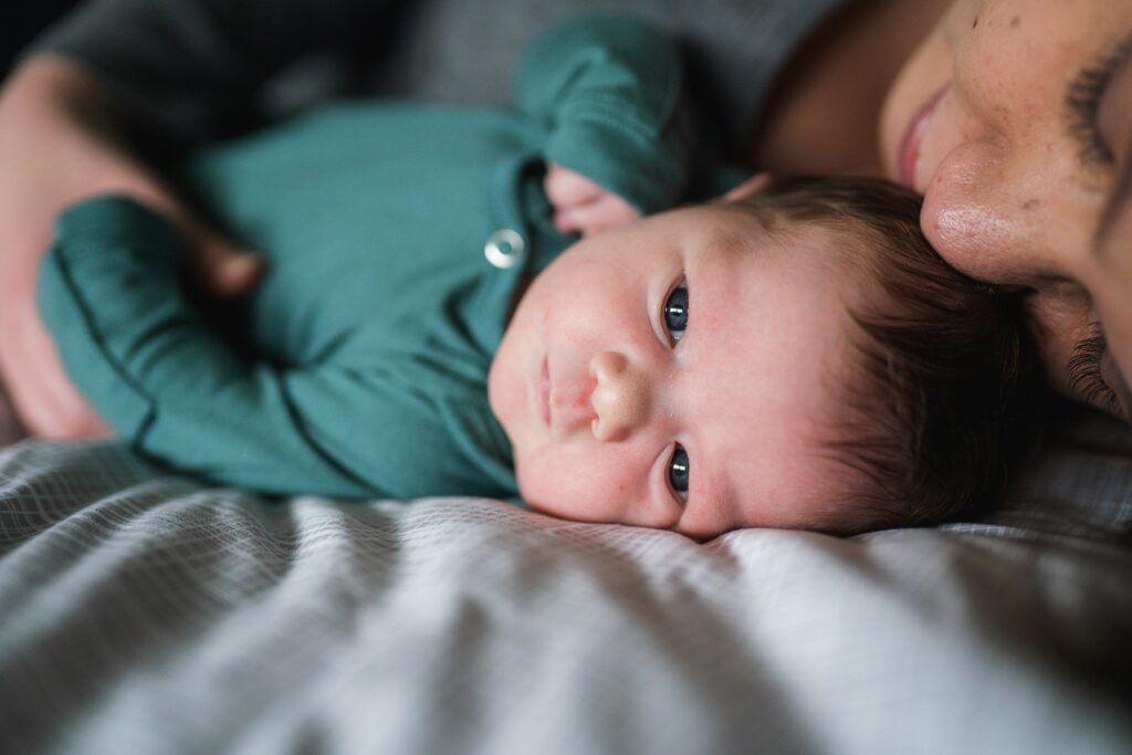 Baby girl dressed in teal showing example of what baby should wear for newborn photos during Seattle area portrait session