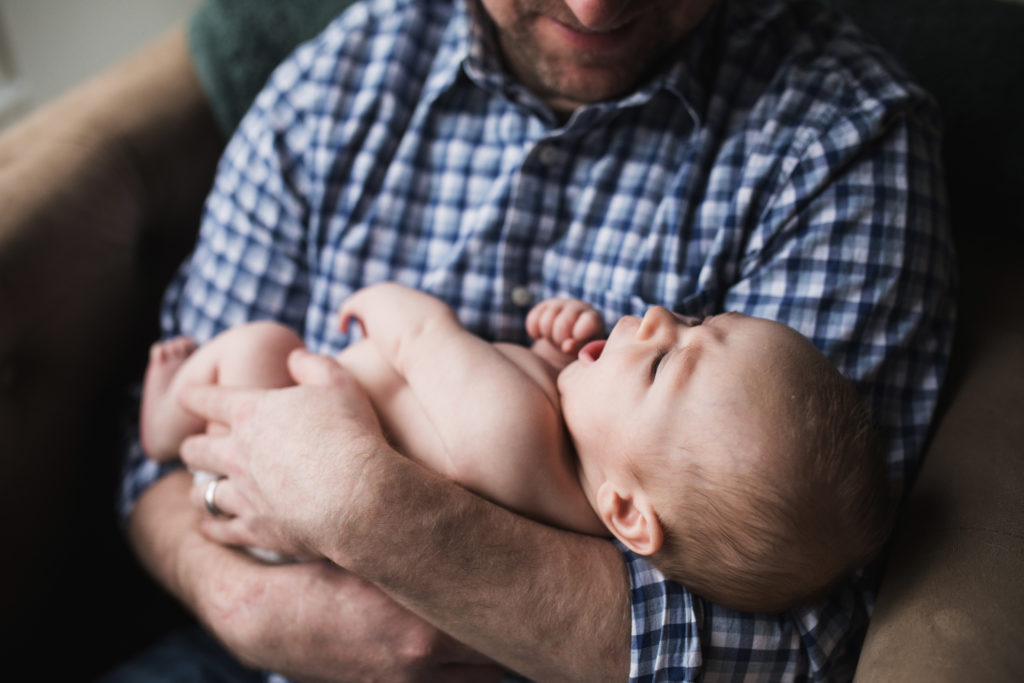 baby in dad's arms during newborn photos at 6 weeks old