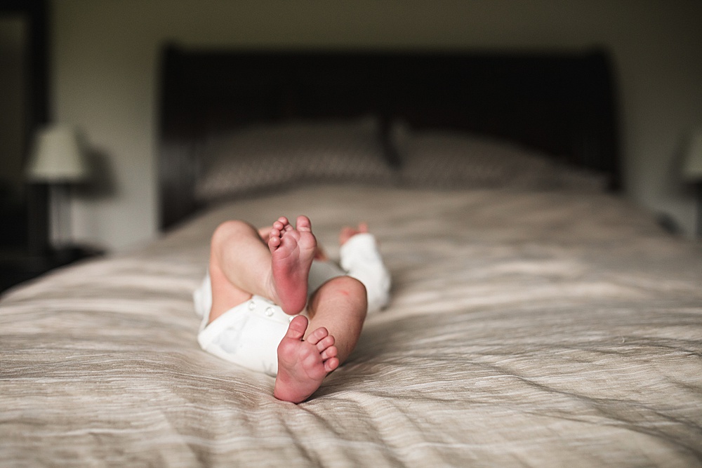 newborn baby toes on bed during an in home newborn photo session