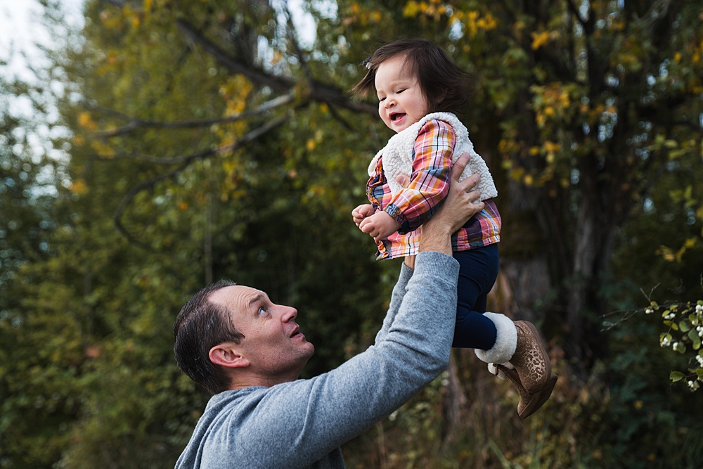 Photo of dad playfully tossing daughter into the air
