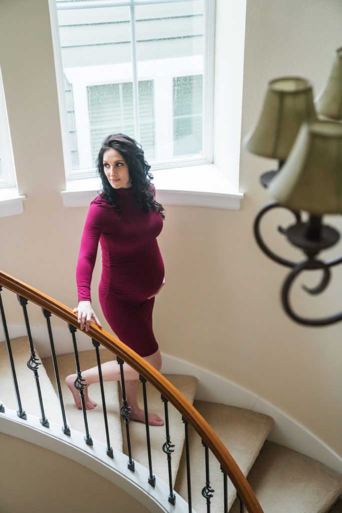 Seattle in home maternity shoot, pregnant woman walking down curved staircase