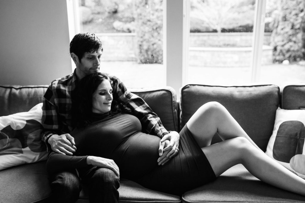Seattle in home maternity shoot, husband and wife on couch together