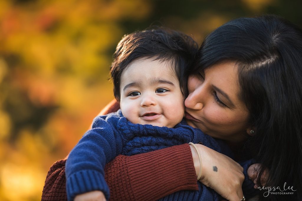 Fall family photos, photo of mother kissing baby with beautiful fall color